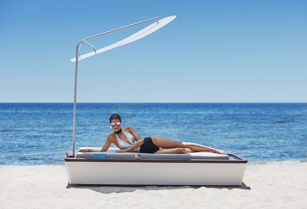Unveiling the WORLD'S MOST ADVANCED SUNBED which automatically applies sun protection, incorporates motorised seat adjustment, reclines to a position designed to simulate weightlessness and secures valuable items within its built-in safe. This luxury lounger also rotates 360 degrees meaning sunbathers can follow or shelter from the sun's rays, while state-of-the-art UV and Vitamin D monitoring technology feeds alerts back to the user's smartphone. The SIMBA BLUE, unveiled today (Wednesday) at prestigious Ibiza beach club Blue Marlin by top British model Sarah Ann Macklin, also features a wi-fi hotspot, solar-powered phone charger and drinks cooler. High-tech mattress makers SIMBA took 7 months, totalling 5,000 hours of innovative research to create the lounger which is available on pre-order for £45,000. PICTURE SHOWS: British model Sarah Ann Macklin on the SIMBA BLUE sunbed with parasol, security safe (left on bed), drinks cooler (centre) and solar charging panels (right on bed).(Handout images by Simba Sleep - video available via media enquiries: nadia.goodman@exposure.net / +44 (0)7447 924 106 or daisy.edwards@exposure.net +44 (0)7958 470736 or simba@exposure.net